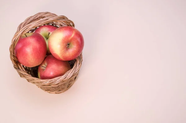 Ένα Κοντινό Πλάνο Φρέσκα Μήλα Ένα Υφαντό Καλάθι Απομονωμένο Ροζ — Φωτογραφία Αρχείου