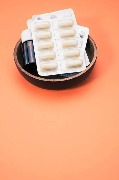 Een Kom Met Medicijntabletten Capsules Flessen Geïsoleerd Een Oranje Achtergrond — Stockfoto