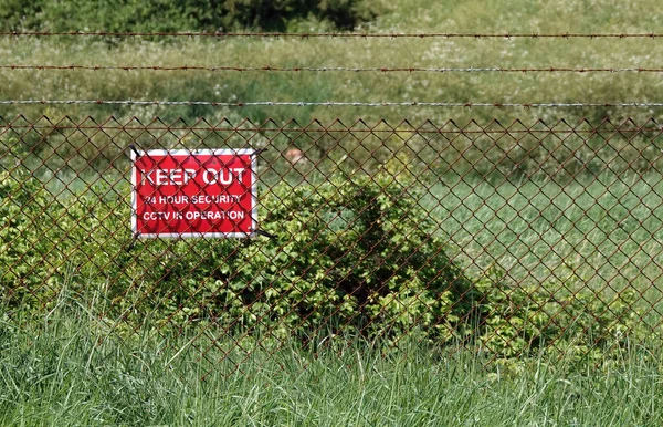 Closeup Keep Out Warning Sign Hanging Cyclone Wire Fence Private — Stock Photo, Image