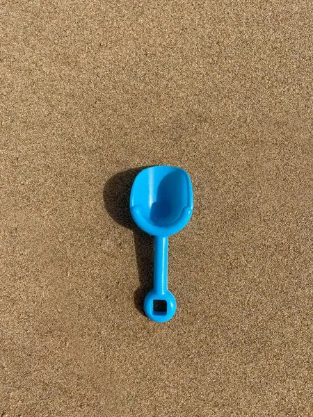 茶色の表面に青いおもちゃのシャベルの閉鎖 — ストック写真