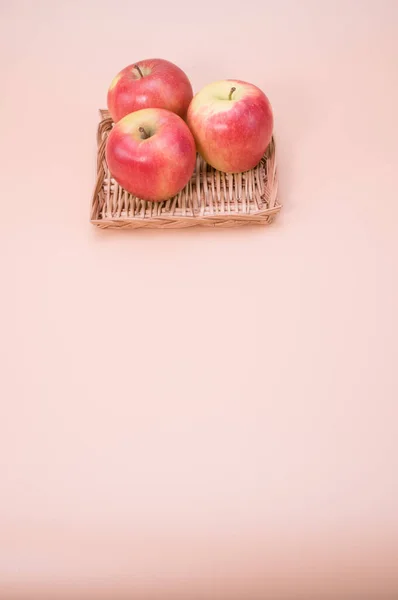 Een Verticaal Shot Van Verse Appels Een Geweven Dienblad Geïsoleerd — Stockfoto