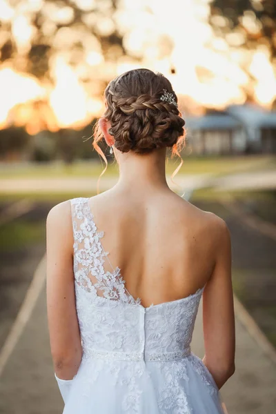 髪の毛が屋外で行われたブライダルドレスで若い女性の垂直ショット — ストック写真