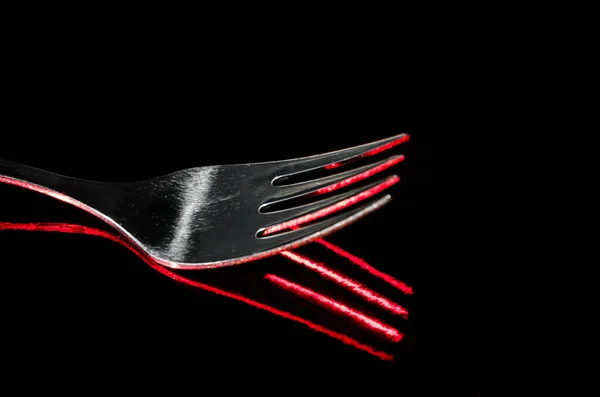 Closeup Shot Stainless Fork Reflecting Red Pattern Dark Background — Stock Photo, Image