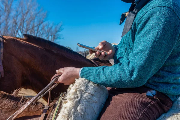 携帯電話を使って馬に乗ってアルゼンチンのガウチョ — ストック写真