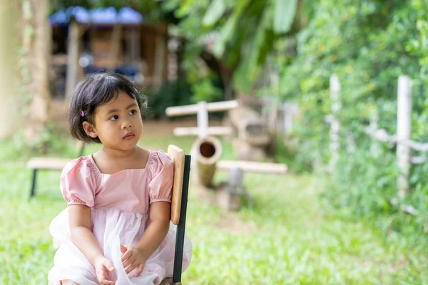 Ένα Χαριτωμένο Ασιατικό Μικρό Κορίτσι Κάθεται Μια Καρέκλα — Φωτογραφία Αρχείου