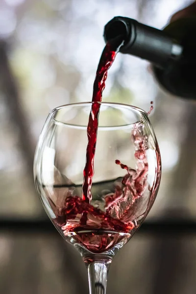 Closeup Shot Red Wine Pouring Glass Isolated Blurry Background — Zdjęcie stockowe