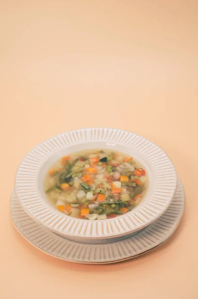 Vertikální Záběr Zeleninové Polévky Misce Izolované Světle Oranžovém Pozadí — Stock fotografie
