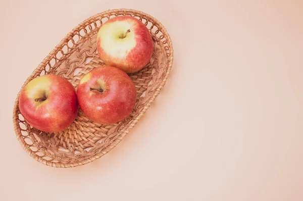 Ένα Κοντινό Πλάνο Φρέσκων Μήλων Ένα Υφαντό Δίσκο Απομονωμένο Ροζ — Φωτογραφία Αρχείου