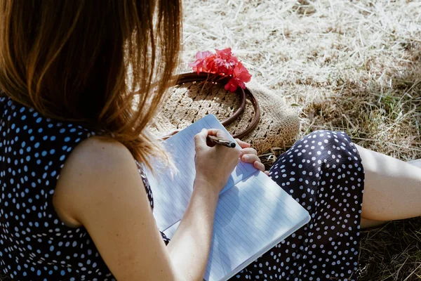 Uma Mulher Sentada Grama Escrevendo Notas Seu Caderno — Fotografia de Stock