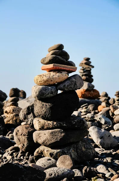 Вертикальный Снимок Каменных Стопок Пляже Фоне Голубого Неба — стоковое фото
