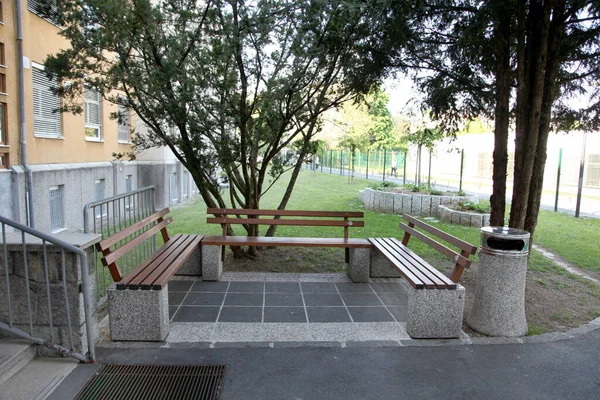 A sitting spot next to the school entrance with three benches