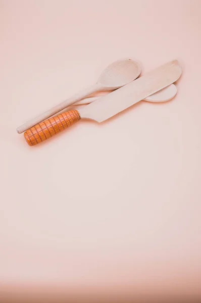 Vertikální Detailní Záběr Dřevěné Lžíce Nůž Estetickém Broskvovém Pozadí Kopírovacím — Stock fotografie