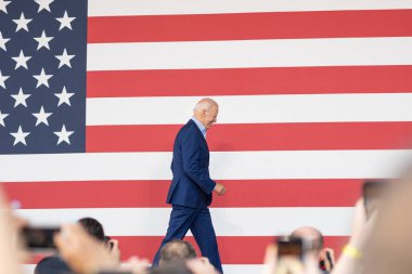 ARLINGTON VA, UNITED STATES - Jul 24, 2021: Joe Biden walking on stage at a campaign rally for Terry McAuliffe in Arlington Virginia. clipart