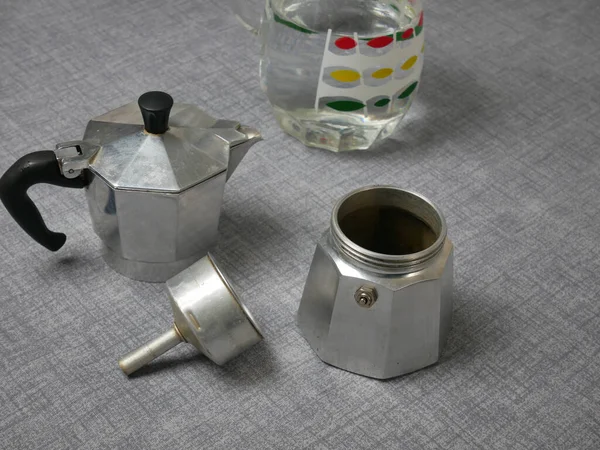 灰色の表面に分解されたモカ鍋と水の瓶の閉鎖 — ストック写真