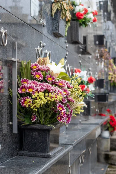 Eine Vertikale Flachbild Aufnahme Von Blumensträußen Unter Dunklen Marmorgrabsteinen Auf — Stockfoto