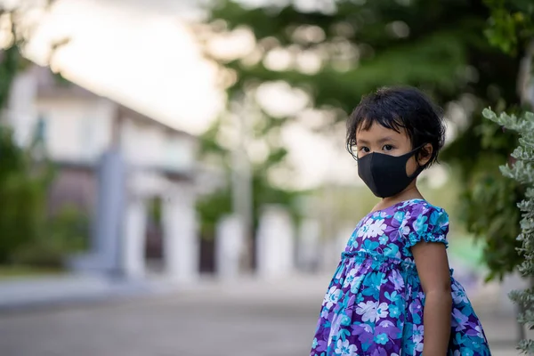 黒の保護マスクをした可愛いアジア系女性の子供 — ストック写真
