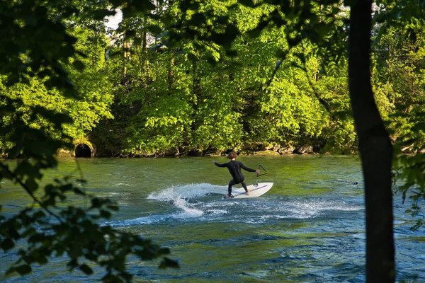 Człowiek Surfujący Desce Surfingowej Rzece Otoczony Zielonymi Drzewami — Zdjęcie stockowe