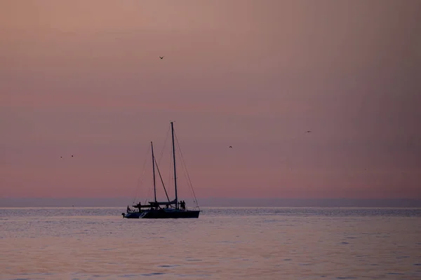 Μια Βάρκα Που Κολυμπάει Στον Ωκεανό Ηλιοβασίλεμα — Φωτογραφία Αρχείου