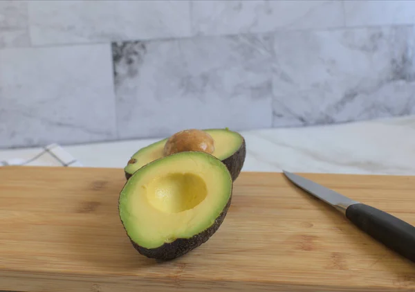 Eine Nahaufnahme Von Aufgeschnittener Avocado Auf Einem Holzbrett — Stockfoto