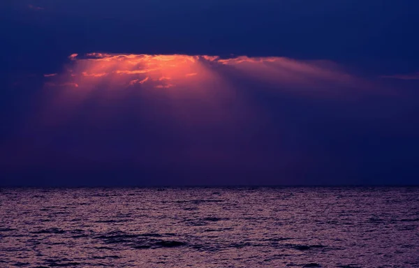 太陽が雲を通して輝く海の上に魅惑的な夕日の風景 — ストック写真