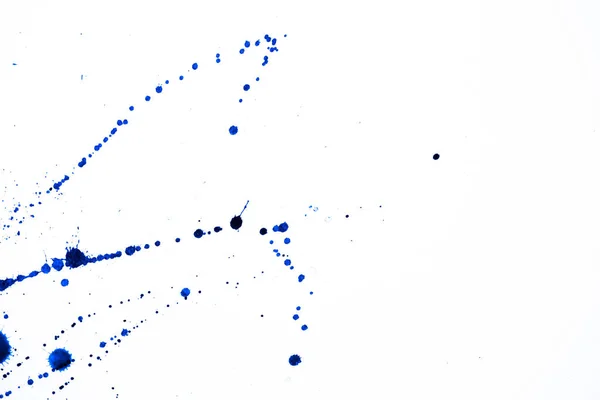 一种凌乱的蓝色墨水 散落在有复制空间的白色表面上 — 图库照片