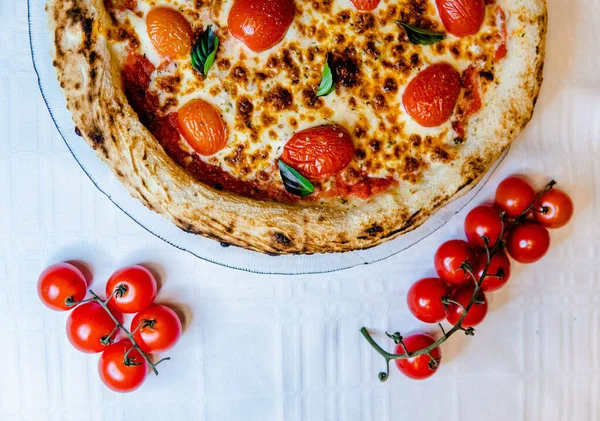 Horní Pohled Půlku Lahodné Pizzy Sýrem Cherry Rajčaty Dřevěném Stole — Stock fotografie