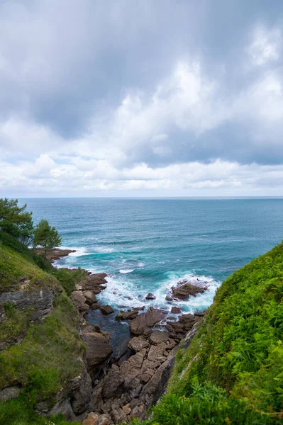 Pionowe Ujęcie Przyjemnej Sceny Błękitnego Morza Nieba Skał Zielonych Wzgórz — Zdjęcie stockowe