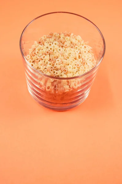 Ein Glas Makkaroni Pasta Auf Orangefarbenem Hintergrund Mit Freier Textfläche — Stockfoto