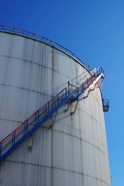 石油精製工場の大きな白いタンクの横にある階段の垂直ショット — ストック写真
