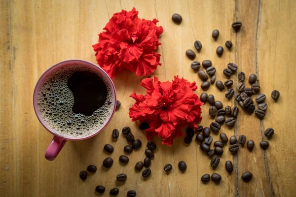 Duże Ujęcie Kąta Filiżanki Kawy Ziarnem Kawy Kwiatami Drewnianej Powierzchni — Zdjęcie stockowe
