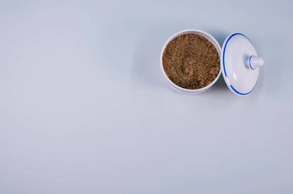 灰色桌子上的一个小陶瓷罐子里的红糖的顶视图 — 图库照片