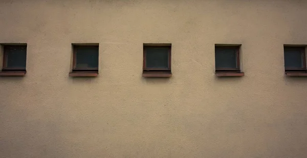 Eine Nahaufnahme Von Reihen Quadratischer Fenster Auf Einer Cremefarbenen Hauswand — Stockfoto