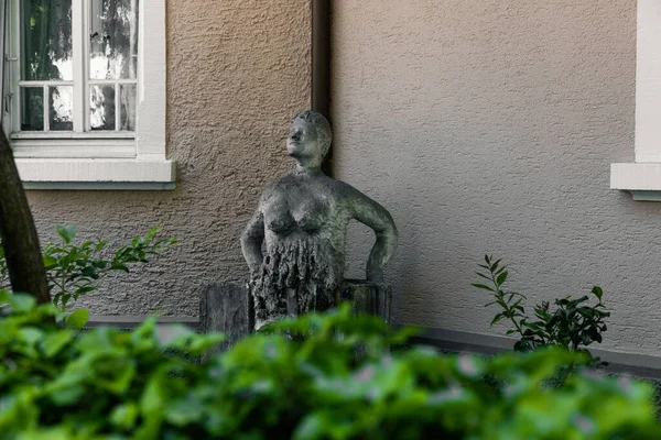 Uma Estátua Velha Plantas Verdes Frente Uma Casa — Fotografia de Stock