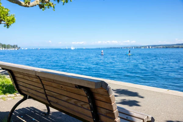 晴れた日には澄んだ青い空とドイツのコンスタンス湖の一本の木製のベンチ — ストック写真