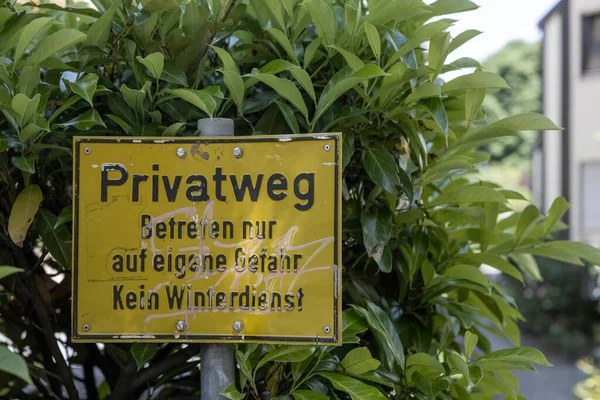 德国的一个黄色私家小路标 后面有茂密的绿色灌木丛 — 图库照片