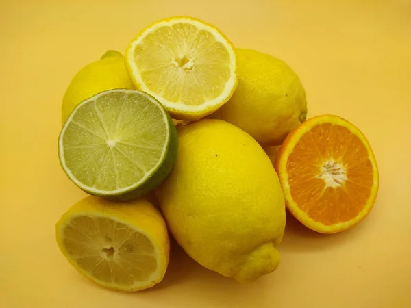Frische Orangen Zitronen Limetten Und Mandarinen Auf Einem Gelben Tisch — Stockfoto