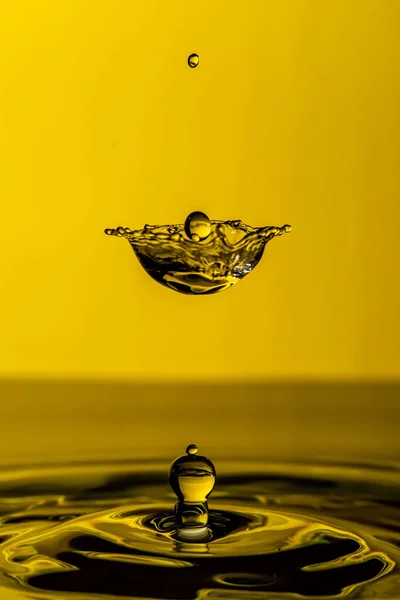 Прекрасний Знімок Бризки Води Краплі Повітрі Жовтому Тлі — стокове фото