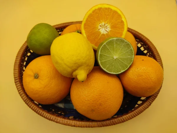 Frische Orangen Zitronen Limetten Einem Korb Auf Einem Gelben Tisch — Stockfoto