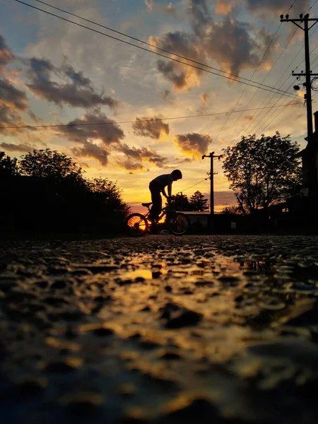 一个年轻男孩在日落时骑自行车的漂亮照片 — 图库照片