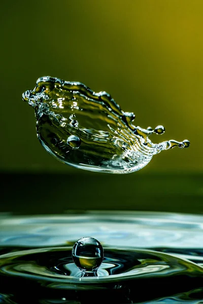 緑の背景に水の飛沫と空気中の液滴の美しいショット — ストック写真
