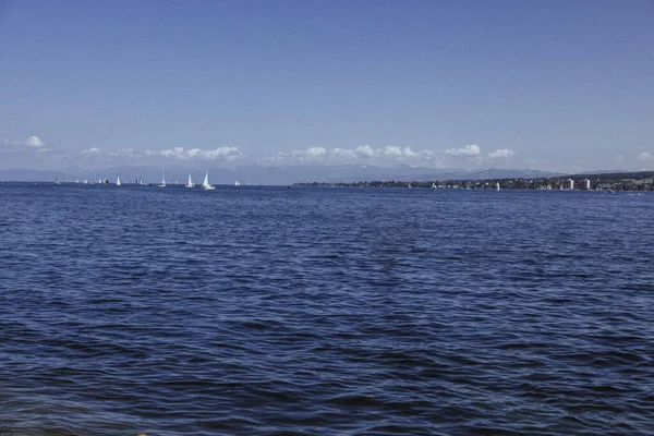透き通った空と海岸近くに浮かぶ船が美しい青い波の海 — ストック写真