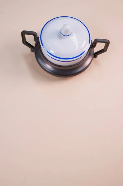米色表面上的一个小陶瓷香料罐的垂直镜头 — 图库照片