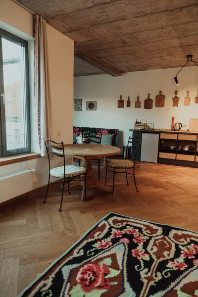 テーブルと椅子を備えたロフトスタイルの部屋のインテリア 引き出し 床にカラフルなカーペット — ストック写真