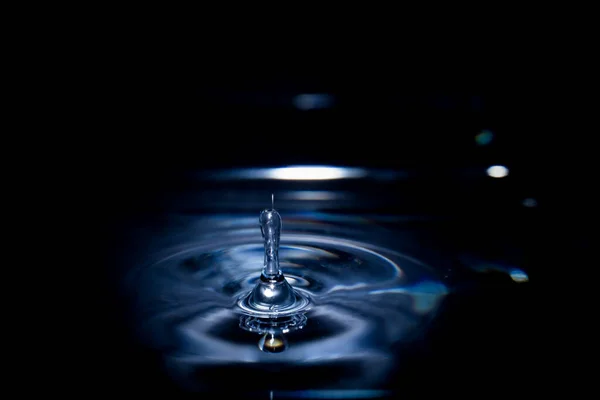 水滴在暗暗模糊背景的池塘中的水滴的选择性焦点 — 图库照片