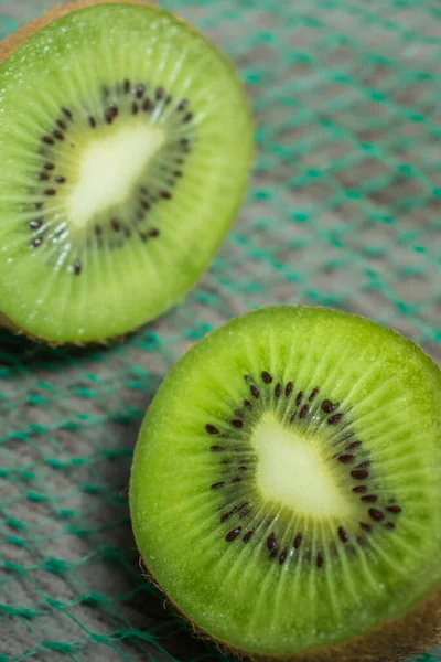 Lovitură Verticală Kiwi Tăiată Jumătate Plasă Verde — Fotografie, imagine de stoc