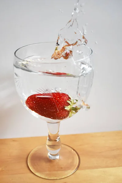 Disparo Vertical Una Fresa Caído Vaso Con Agua —  Fotos de Stock