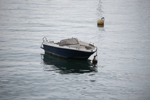 背景にブイを持つ海の水の中の小さなボートの高角度ショット — ストック写真