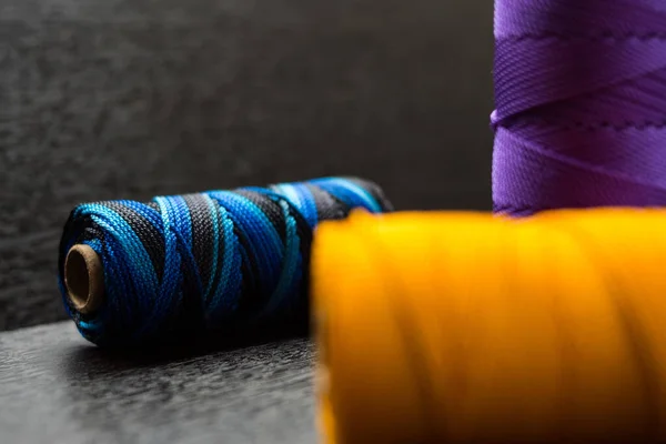 暗い背景に異なる色の毛糸の皮を編むの高角度ショット — ストック写真
