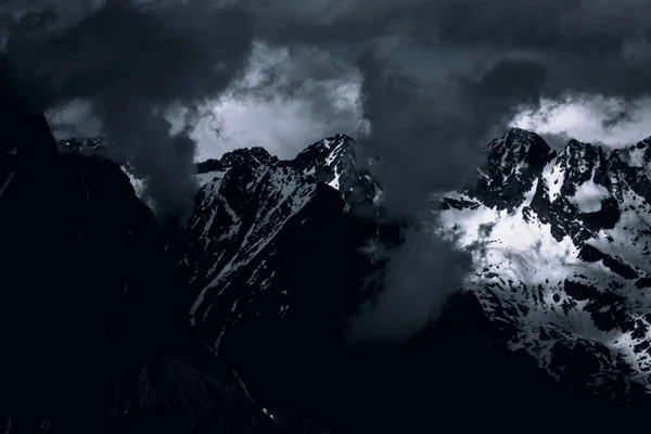 Uma Paisagem Montanhas Rochosas Cobertas Neve Sob Céu Escuro Nublado — Fotografia de Stock