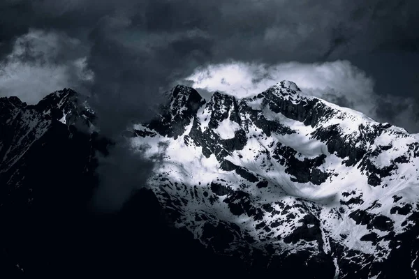 Uma Paisagem Montanhas Rochosas Cobertas Neve Sob Céu Escuro Nublado — Fotografia de Stock